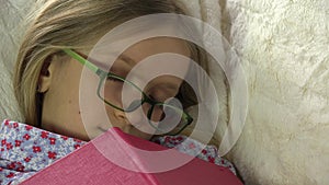 Child sleeping after reading book, kid fall asleep in her bed, girl at home
