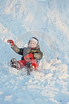 Child slides down a snowy hill