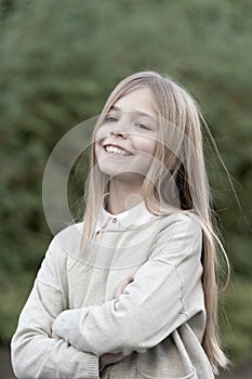 Child with smile on cute face outdoor. Little girl with long blond hair. Beauty kid with fresh look and skin. Beauty
