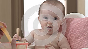 A child smiles and eats porridge