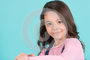 Child smiling with long brunette hair, hairstyle