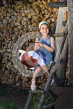 Child smiling with no teeth sitting near the wooden wall of the shed