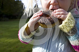 Child snacking on unhealthy chocolate donut