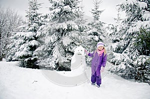 Child, snowman and winter forest