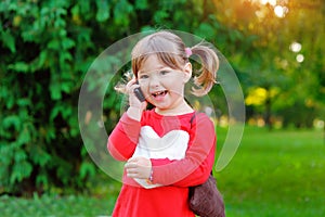 Child speaks on the phone in the park