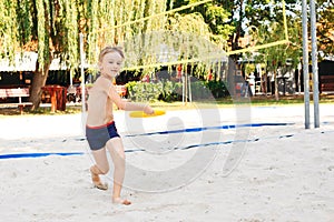Child spending carefree time outdoors. Summer camp. Cute little boy playing with frisbee outdoors