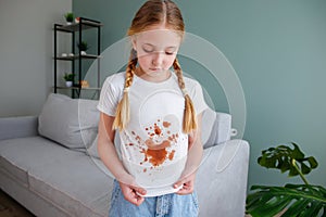 The child spilled coffee on his clothes. The concept of a stain on a t-shirt