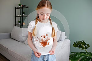 The child spilled coffee on his clothes. The concept of a stain on a t-shirt