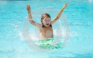 Child splashing in summer water pool. Kid splash in pool. Excited happy kid boy jumping in pool, water fun. Kid jumping