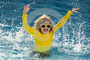 Child splashing in summer water pool. Kid splash in pool. Excited happy kid boy jumping in pool, water fun. Kid jumping