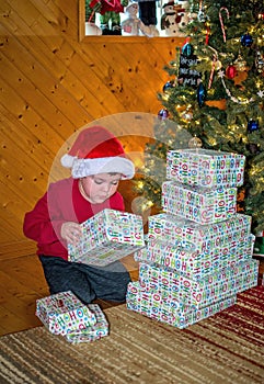 Child with stack of gifts under the Christmas tree