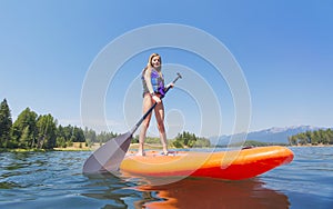Child on a Stand Up Paddle board on a beautiful Mountain lake