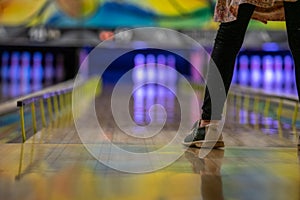 Child standing on bowling lane ready to throw bowling ball