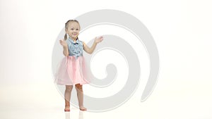 Child is standing and clapping wannabes and twisting his arms around. White background