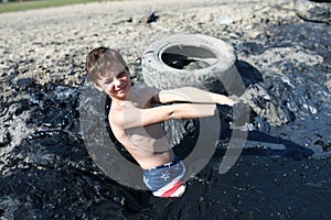 Child standing in pool of healing mud