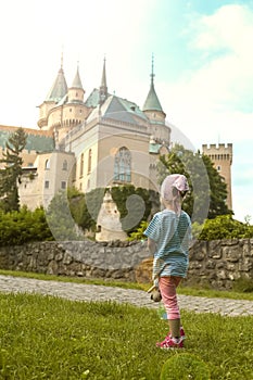 Child stands in front of castle in Bojnice