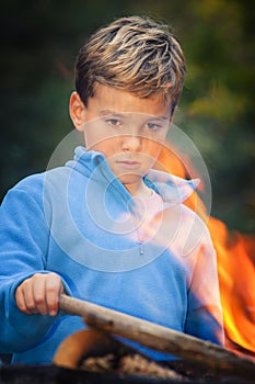 Child staring at campfire