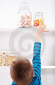 Child stealing candy from the shelf