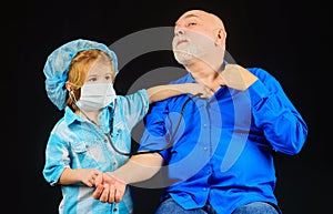 Child with Stethoscope play doctor with grandpa. Kid boy doctor playing with grandfather. Boy in doctor mask. Treatment.
