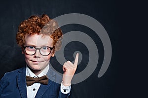 Child student pointing up on chalkboard background