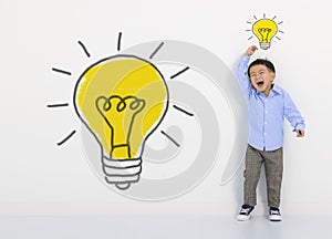 Child student thinking and light bulb on the white wall . Cute little boy has an new idea. Innovation technology and education con