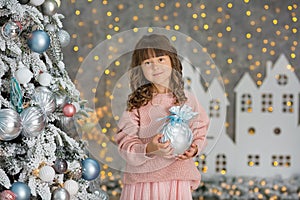 A child in the studio for the New Year. Girl in a Christmas photo session. Festive mood. Waiting for a miracle in the Birth