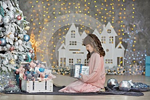 A child in the studio for the New Year. Girl in a Christmas photo session. Festive mood. Waiting for a miracle in the Birth