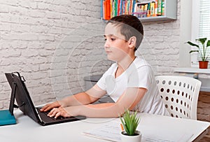 Child studying at home looking at laptop screen during quarantine