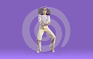 Child in stylish casual outfit dancing gangnam style on purple studio background