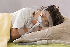 Child suffering from Sleep Apnea, wearing a respiratory mask