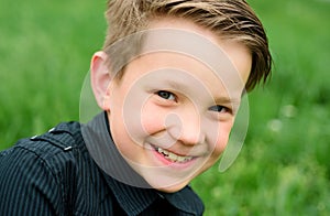 Child in summer park. Baby face closeup. Funny little kid boy close up portrait. Blonde kid, smiling emotion face. Happy
