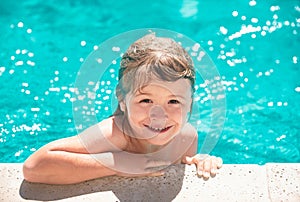 Child in summer swimming pool. Little boy playing in outdoor swimming pool in water on summer vacation. Child learning