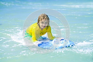 Child summer vacation at sat. Summer vacation with child. Surfer child is riding a wave. Kid learning to surf in sea or