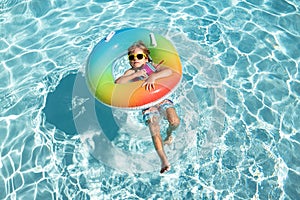 Child summer vacation. Summertime weekend. Boy in swiming pool. Happy boy on inflatable rubber circle.