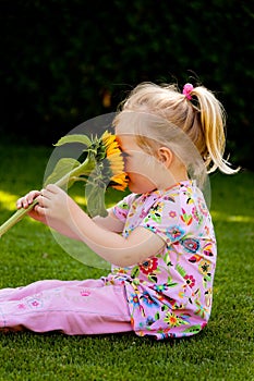 Child with sunflowers in the garden in summer