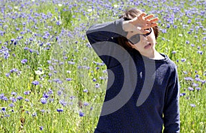 Child suffering from hot temperature and climate change, cornflower background