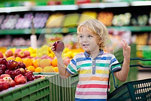 Child in supermarket. Kid grocery shopping