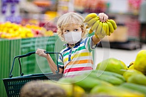 Child in supermarket. Kid grocery shopping