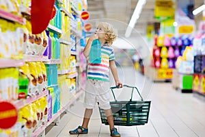 Child in supermarket. Kid grocery shopping