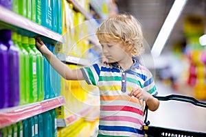 Child in supermarket. Kid grocery shopping