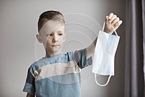 Child in a surgical mask. Boy wearing a medical mask for protect them self from coronavirus and flu outbreak