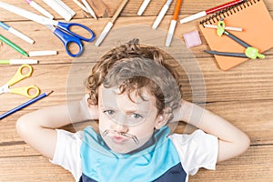 Child surrounded by school supplies