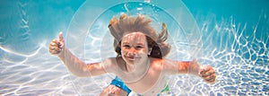 Child swim and dive underwater in the swimming pool.