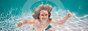 Child swim and dive underwater in the swimming pool.