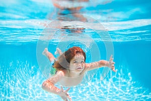 Child swim and dive underwater in the swimming pool. Summer kids activity, watersports.