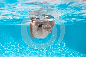 Child swim and dive underwater in the swimming pool. Summer vacation with children.