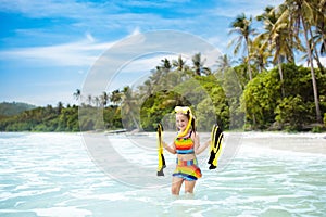 Child with swim fins snorkeling on tropical beach. photo