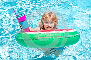 Child swim in poolside in water background. Kid in swimming pool, relax swim on inflatable ring and has fun in water on