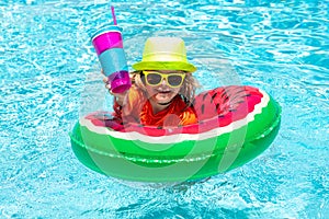 Child swim in summer pool water. Child in swimming pool playing in water. Vacation and traveling with kids. Children