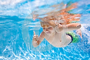 Child swim under water in sea. Kid swimming in pool underwater. Happy boy swims in sea underwater, active kid swimming